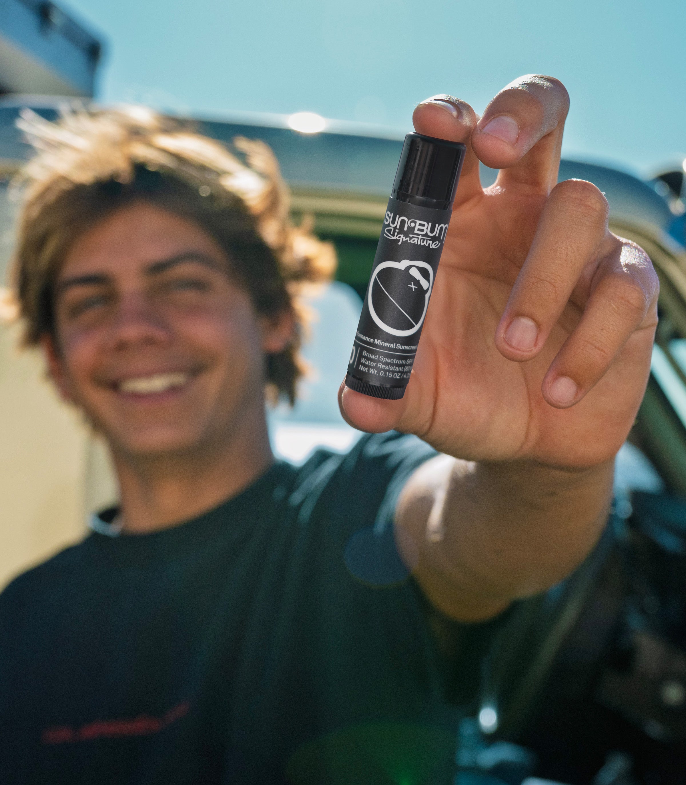 Sun Bum Australian Ambassador Lungi Slabb holding Signature Lip Balm