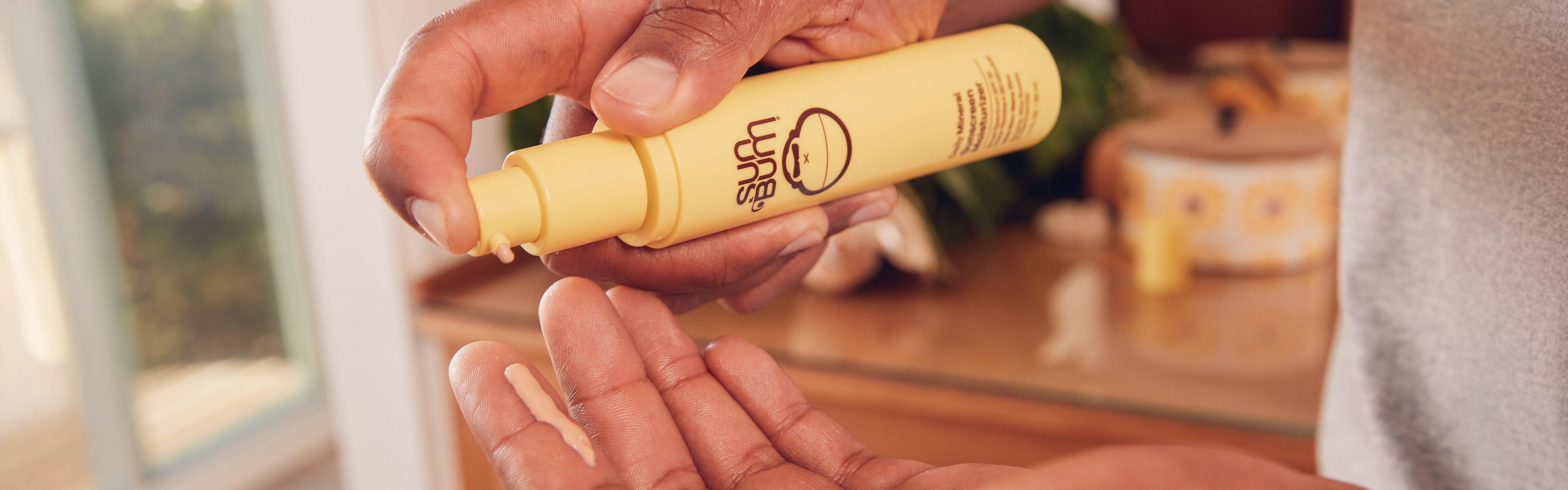 Close up of hands putting on sun bum skin care