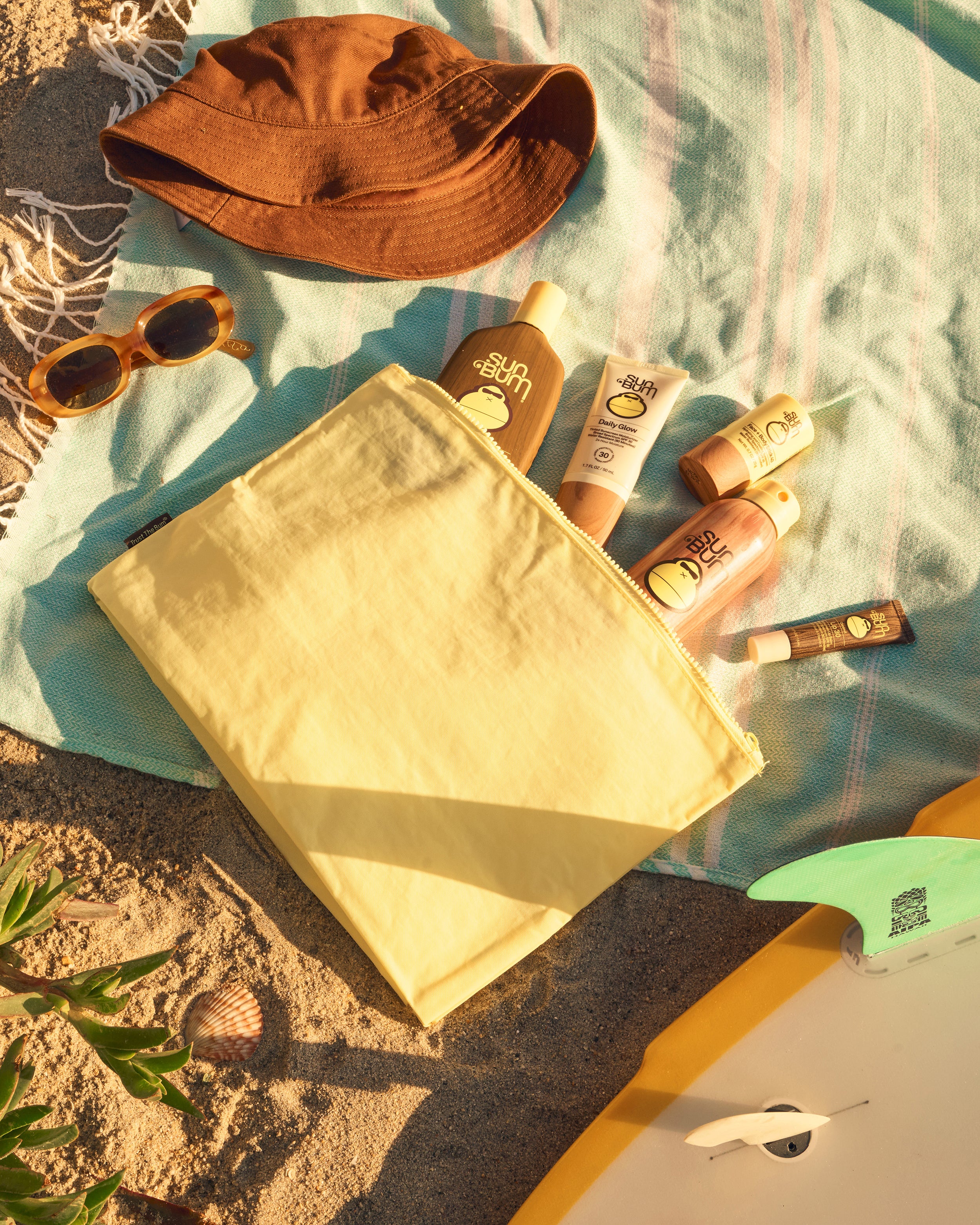 Flat lay of the Sn Bum yellow BYOB bag filled with Sun Bum product 