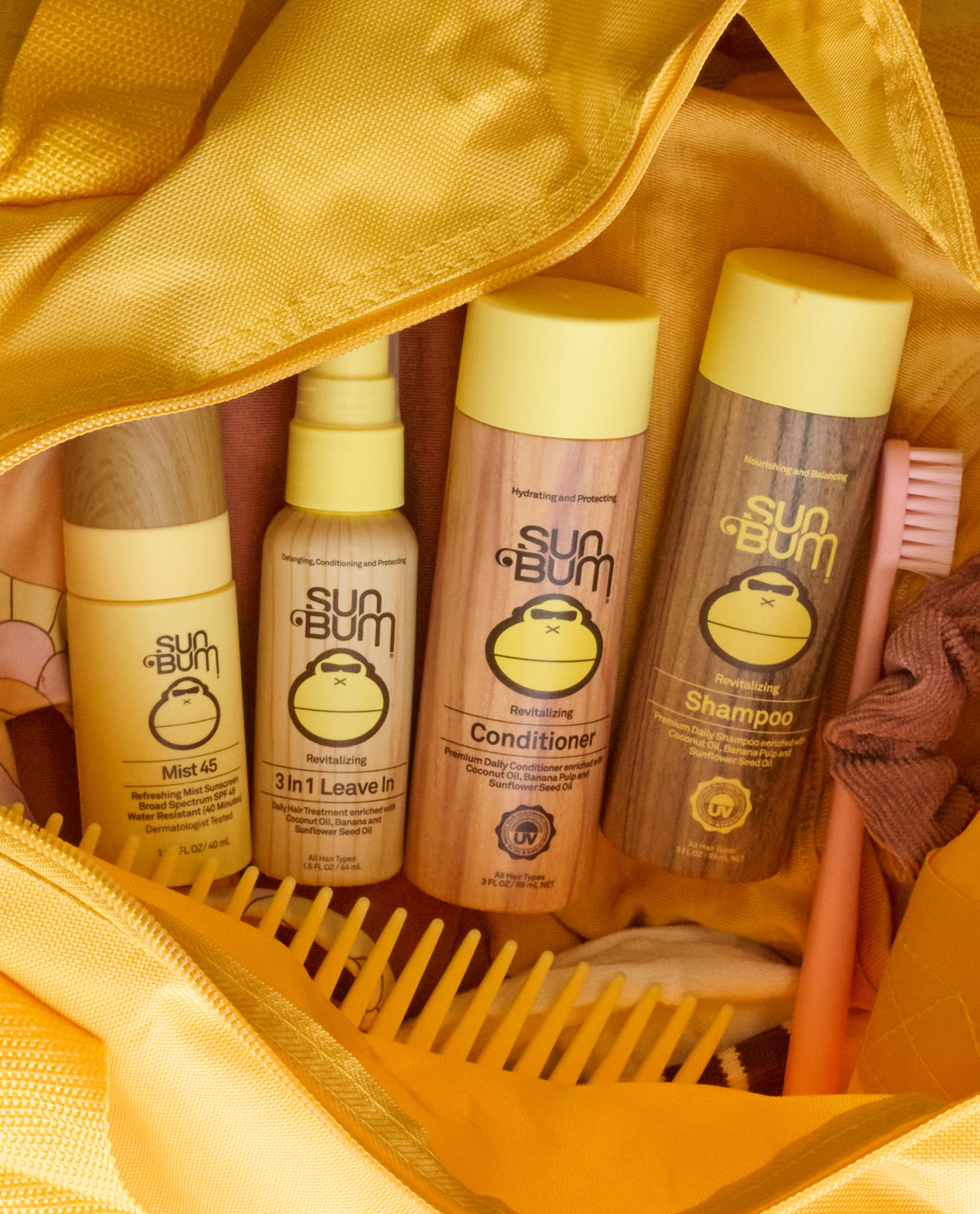 Sun Bum skincare products in a yellow bag with a comb and toothbrush.