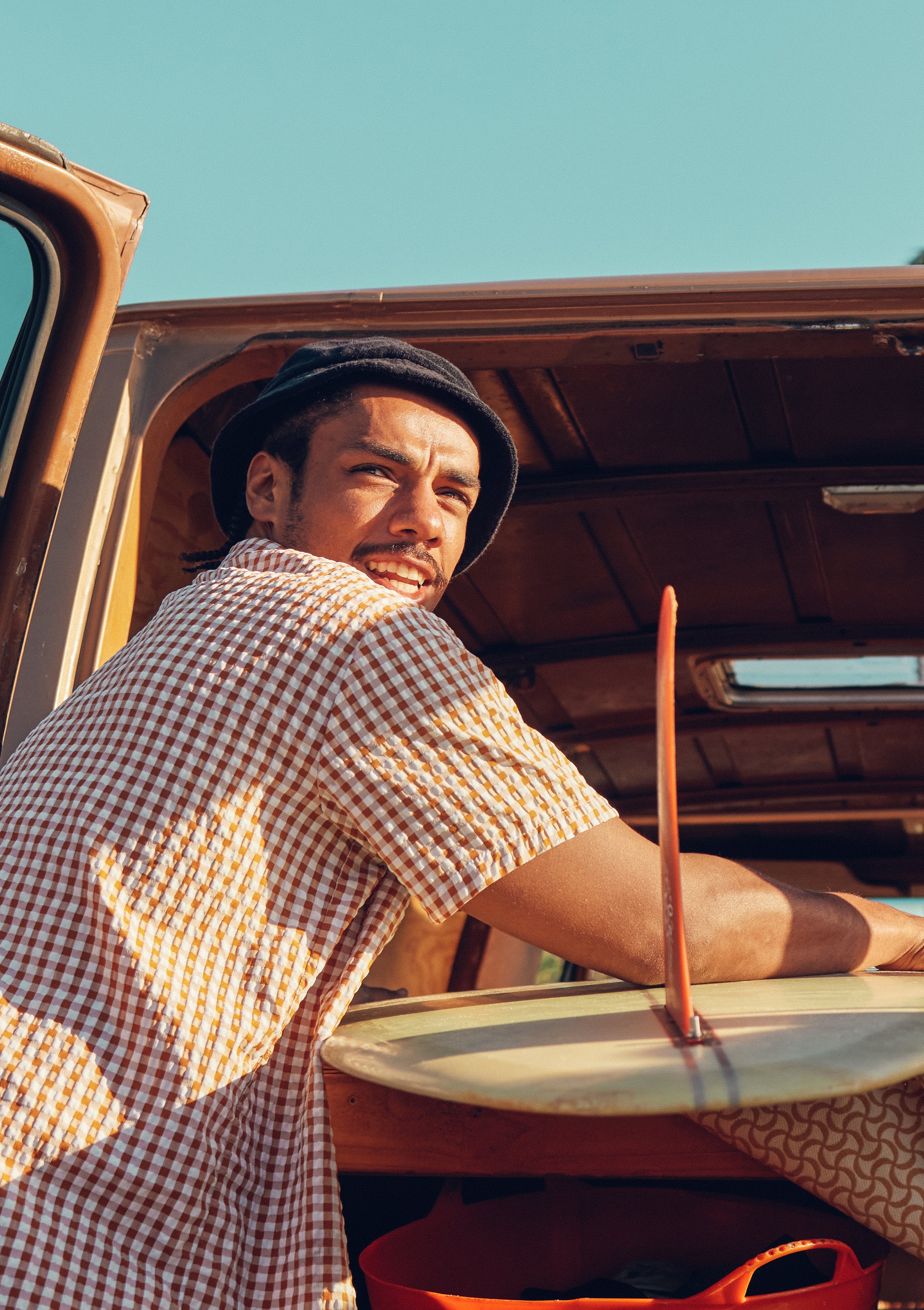 Surfer loading a board into a van, getting ready for a beach day under the sun – Promo Blocks Lifestyle Sun Collection - Sun Bum.