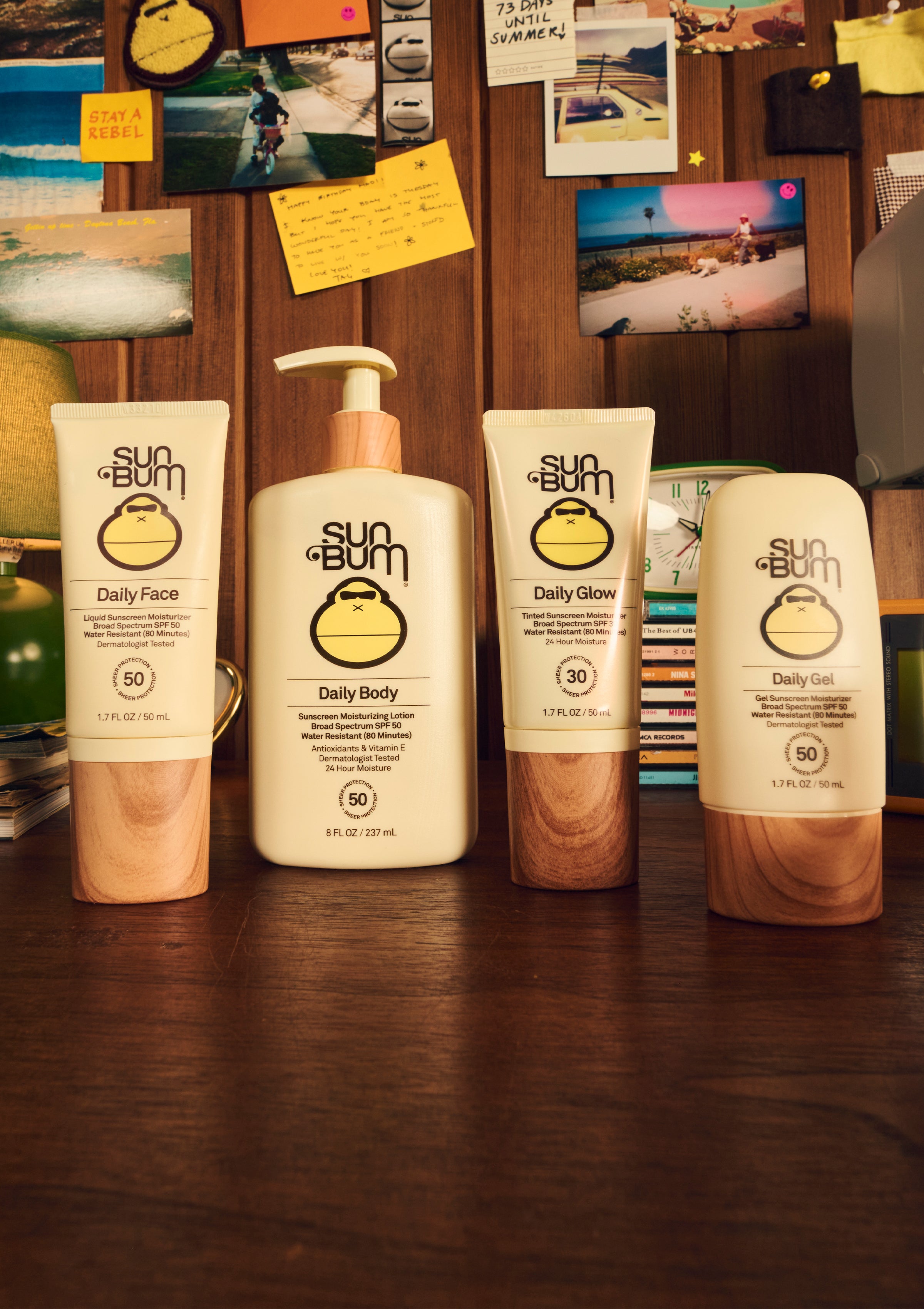 Lineup of Sun Bum Daily sunscreens for face, body, glow, and gel with SPF 30–50 on a desk - Daily Collection - Sun Bum