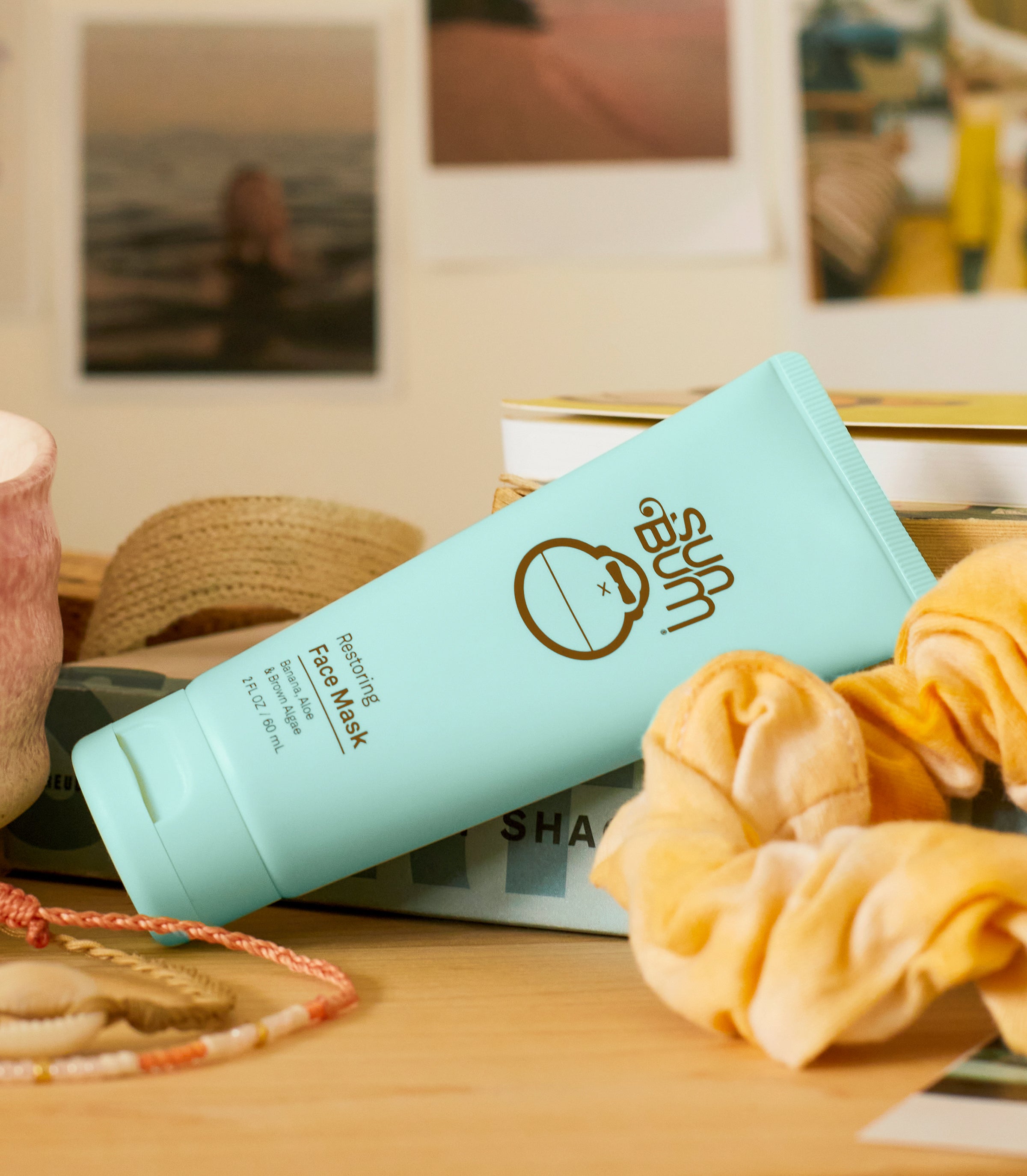 Sun Bum Restoring Face Mask on a desk with scrunchies and beachy decor, from the SB Restoring Skin Care Collection – Sun Bum.