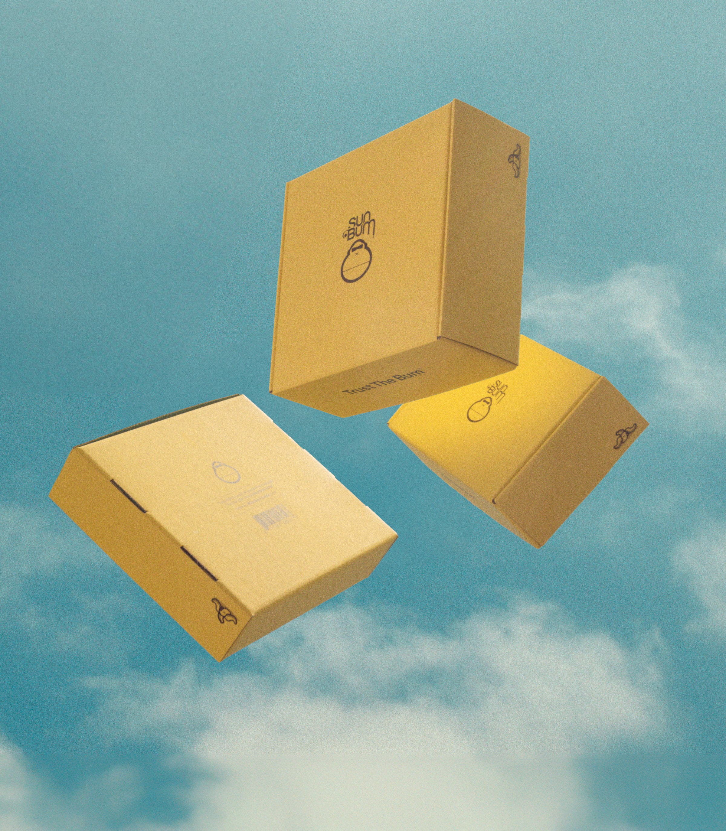 Three yellow Sun Bum shipping boxes floating in a blue sky with clouds – Shipping & Returns Collection - Sun Bum.